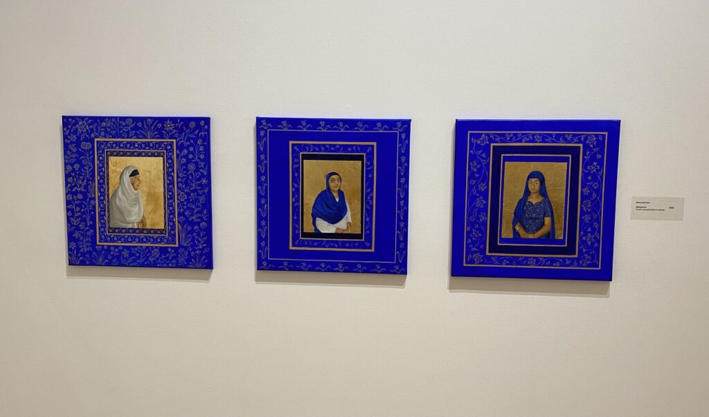 A set of blue and gold paintings. Each has a portrait of a woman on it.